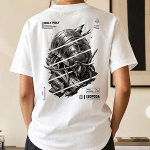 Może przedstawiać: Biały t-shirt z czarno-białą grafiką na plecach przedstawiającą stonogę. Projekt zawiera napisy ROLY POLY, ARMORED SCAVENGER INVERTEBRATES, ISOPODA oraz ROLLED DEFENSE DIVISION, wraz z technicznymi oznaczeniami współrzędnych.