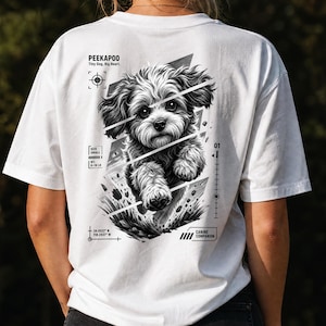 Può includere: Una t-shirt bianca con una grafica in bianco e nero sul retro raffigurante un cane Peekapoo dal pelo folto. Il design include il testo PEEKAPOO, Tiny Dog, Big Heart, SIZE SMALL, WT. 2,7-8,2 KG, CANINE COMPANION e le coordinate 34.0522 N 118.2437 W.