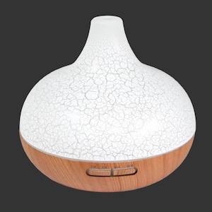 May include: A teardrop-shaped essential oil diffuser featuring a white upper section with a detailed black crackle pattern and a light brown wood-grain base. Two horizontal control buttons are positioned on the front of the wooden base.