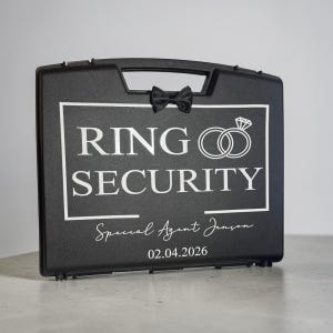 May include: A white ceramic mug with a black handle and the text "But First, Coffee" in a bold, black font. The mug is set against a blurred background, suggesting a cozy setting.