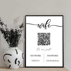 May include: A black and white sign with the word "wifi" in cursive script. A QR code is displayed below the word "wifi" with the text "Be our guest!" below the QR code. The sign also includes the words "NETWORK" and "PASSWORD" with the network name "VM8267514" and the password "rG6bzdhv8hpdbwJm" listed below.