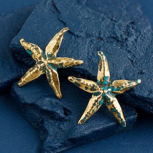 Shiny brass stud earrings in the shape of starfish. Earrings are not flat, they have curves and hollows as they are handmade with hammer and other tools.