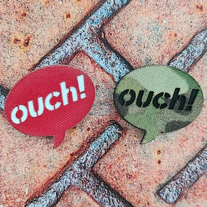 May include: Two speech bubbles, one red with white text and one green with black text, both saying "ouch!"