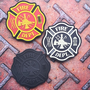 Peut inclure: Trois écussons de pompiers, un rouge et jaune, un noir et blanc et un noir. Chaque écusson représente un casque de pompier, des haches croisées, une échelle et une bouche d'incendie. Les écussons sont tous en forme de croix de Malte et portent l'inscription "FIRE DEPT.".
