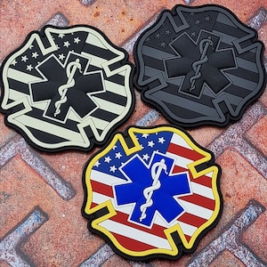 Può includere: Tre toppe ricamate a forma di emblema dei vigili del fuoco con uno sfondo di bandiera americana e un simbolo medico con un serpente. Le toppe sono in nero, bianco e rosso, blu e giallo.