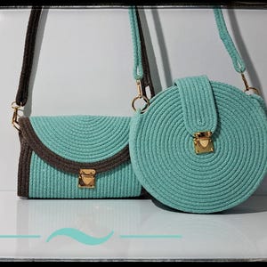 May include: Two turquoise rope handbags with brown accents and gold-colored hardware. One is rectangular with a flap, the other is round with a flap closure. Both have long shoulder straps.