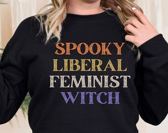 May include: Black sweatshirt with the text "Spooky Liberal Feminist Witch" in orange, yellow, and purple.