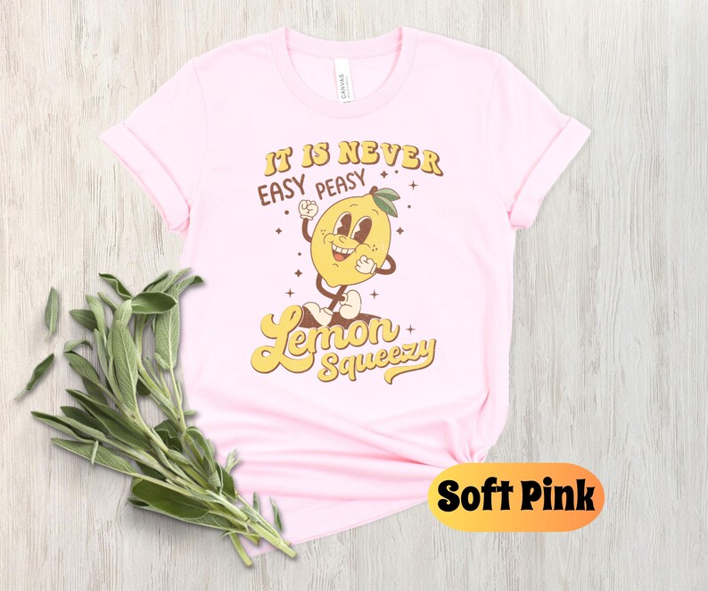 May include: A pink t-shirt with a yellow lemon cartoon character and the text "It is never easy peasy Lemon Squeezy".