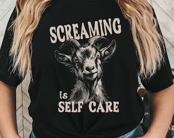 Puede incluir: Camiseta negra con un gráfico blanco de una cabra y el texto "Screaming is Self Care".
