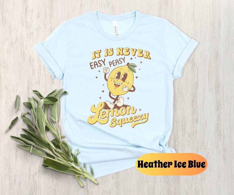 May include: Light blue t-shirt with a cartoon lemon graphic and the text "It is never easy peasy lemon squeezy".