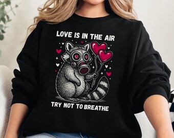 Love Is In The Air Try Not To Breathe Sweatshirt, Funny Anti Valentine’s Day, Raccoon Humor Shirt, Ironic Love Gift, Galentines Day Shirt