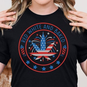 May include: Black t-shirt with a red, white, and blue graphic of a marijuana leaf with fireworks and stars. The text "Red White and Baked" is written in a circle around the graphic.