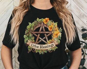 May include: Black t-shirt with a pentagram surrounded by a wreath of leaves and flowers. The text "Litha Blessings" is on a banner below the pentagram.
