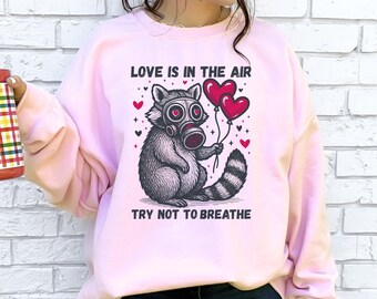 Love Is In The Air Try Not To Breathe Sweatshirt, Funny Anti Valentine’s Day, Raccoon Humor Shirt, Ironic Love Gift, Galentines Day Shirt