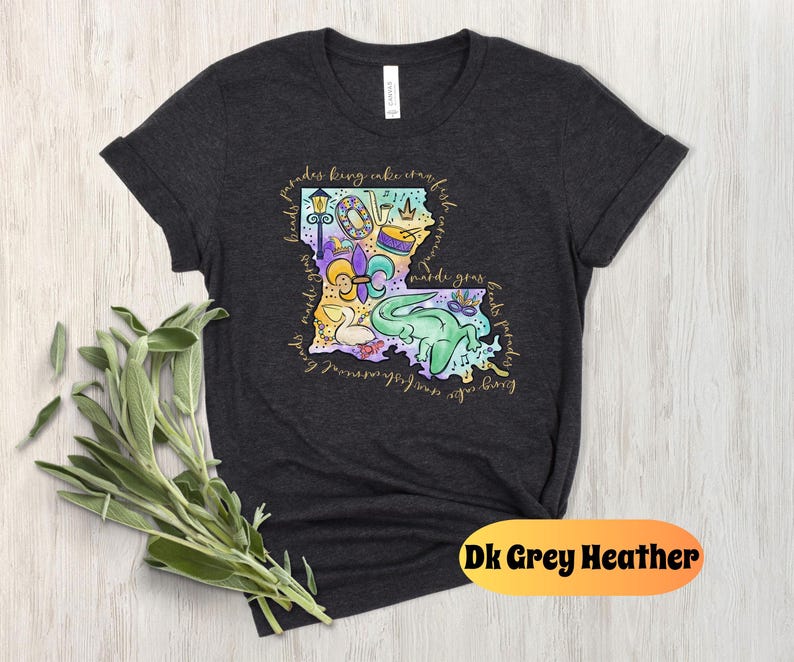Op de afbeelding: Donkergrijs heather t-shirt met een kleurrijke illustratie van de staat Louisiana met Mardi Gras-thema-iconen en de tekst "Friends bring cake, craft beer, and good times. Mardi Gras beads, floats, parades, king cake, crawfish, and music.  NOLA, New Orleans, Lafayette, Baton Rouge, Shreveport, Lake Charles, and more."