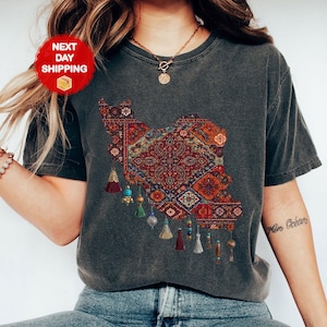 May include: Dark gray heather t-shirt featuring a detailed map design filled with a colorful, intricate rug pattern. The design includes tassels with beads. The shirt has the text "Dark Gray Heather" at the bottom.