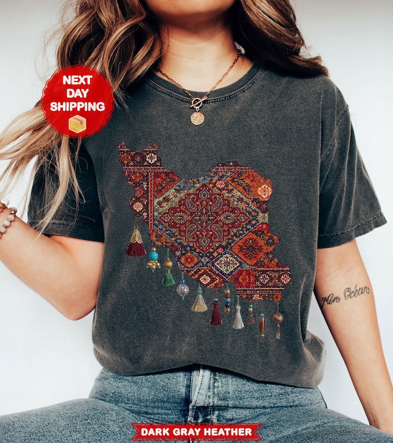 May include: Dark gray heather t-shirt featuring a detailed map design filled with a colorful, intricate rug pattern. The design includes tassels with beads. The shirt has the text "Dark Gray Heather" at the bottom.