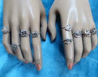 May include: A set of silver rings with different animal designs. The rings are worn on a pair of mannequin hands.