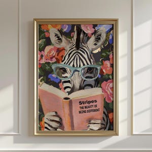 Puede incluir: Una impresión artística enmarcada que presenta una cebra con gafas azules leyendo un libro. La portada del libro es rosa y tiene el texto "Stripes The Beauty of Being Different". El fondo es un estampado floral con flores rosas, naranjas y azules.