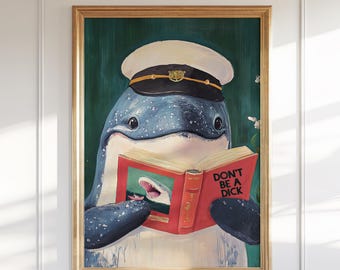 以下が含まれることがあります： キャプテンハットをかぶった青いクジラが本を読んでいるイラストの額入りアートプリント。本の表紙は赤色で「DON'T BE A DICK」と書かれています。背景は濃い緑色で、フレームは金色です。