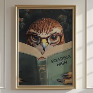 May include: A framed wall art print featuring a brown owl wearing dark-rimmed glasses while reading an open green book. The book cover displays the text SOARING HIGH in dark letters. The owl has sharp talons visible at the bottom of the page.