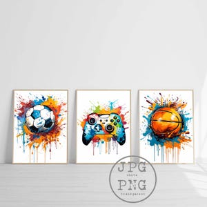 Könnte beinhalten: Set aus drei gerahmten Kunstdrucken mit Aquarellillustrationen. Die Drucke zeigen einen Fußball, einen Videospiel-Controller und einen Basketball, jeweils umgeben von farbenfrohen Farbspritzern. Die Kunstwerke haben einen modernen, abstrakten Stil.