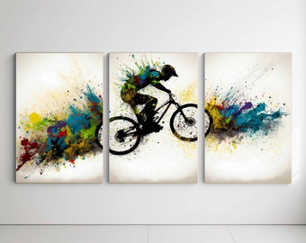 Puede incluir: Un conjunto de tres impresiones de arte abstracto con la silueta de un ciclista de montaña en el aire, rodeado de salpicaduras de pintura de colores.