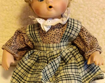 Muñeca de porcelana, muñeca sentada dulcemente.