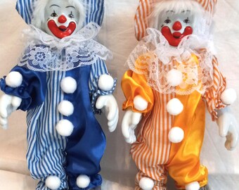 Dos muñecos de payaso de porcelana vintage en su embalaje original.
