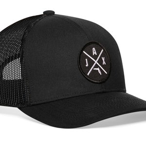 May include: Black trucker hat with a black and white embroidered patch that says "JAX" with a crossed-out gun and a Florida state outline.