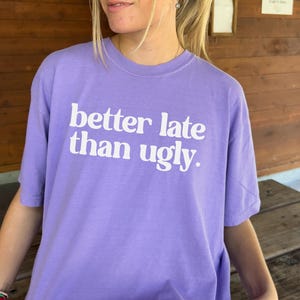 T-shirt with bold orange text that reads better late than ugly in playful retro-style font