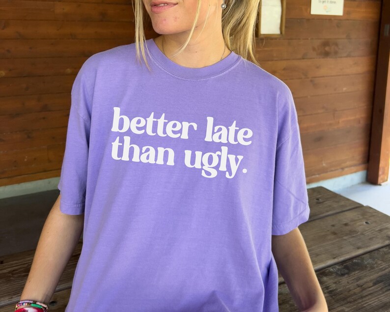 T-shirt with bold orange text that reads better late than ugly in playful retro-style font