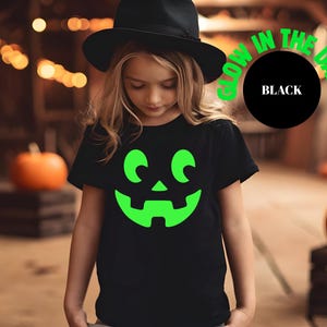 glow pumpkin shirt, halloween matching, jack o lantern face, spooky family shirt, glow in dark tee, halloween tee set, family costume tee, matching pumpkin top, dark grey tee set, halloween graphic, trick or treat outfit, pumpkin glow shirt, halloween night top