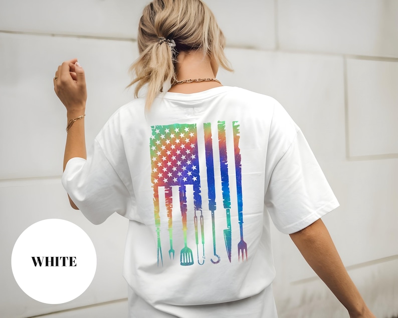 T-shirt featuring a rainbow American flag design made of BBQ grilling tools like tongs, spatula, and fork