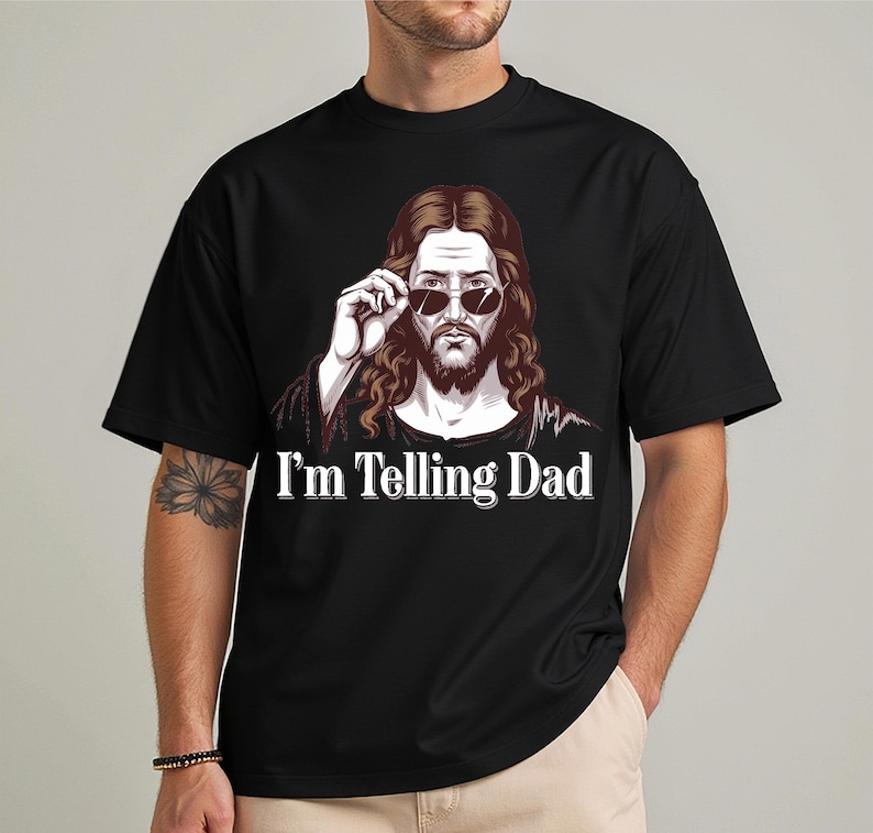 May include: Black t-shirt with a graphic of Jesus wearing sunglasses and the text "I'm Telling Dad".