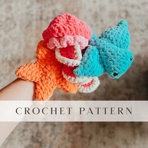 May include: A crochet pattern for a set of three plush toys: a starfish, a jellyfish, and a turtle. The starfish is orange, the jellyfish is pink and white, and the turtle is blue.