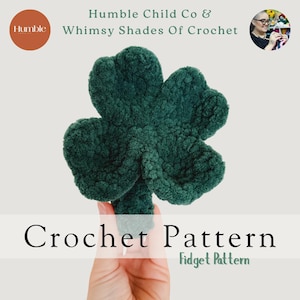 Op de afbeelding: Een handgemaakte, donkergroene gehaakte klaver. De afbeelding bevat de tekst "Crochet Pattern" en "Fidget Pattern". De merknaam "Humble Child Co & Whimsy Shades Of Crochet" is ook zichtbaar.