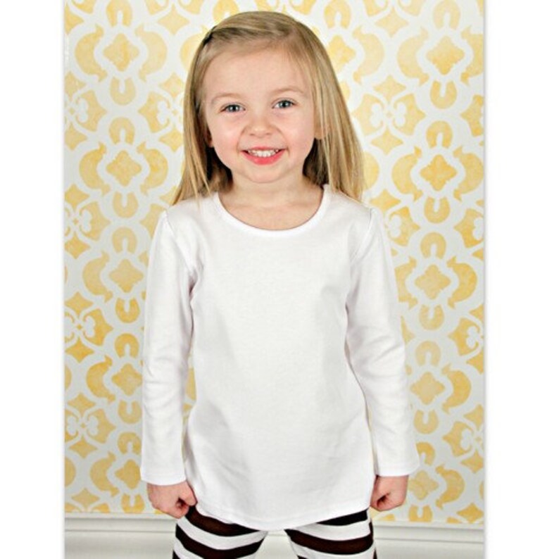 May include: A white long-sleeved shirt with a round neckline. The shirt is made of a soft, comfortable fabric and is ideal for everyday wear.