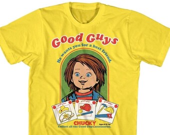 May include: Yellow t-shirt with a graphic of Chucky from the Child's Play movie series. The graphic features Chucky's face and the text "Good Guys" and "He wants you for a best friend."  The graphic also includes three cards with the text "Good Guys" and images of a cowboy hat, a baseball cap, and a hammer.