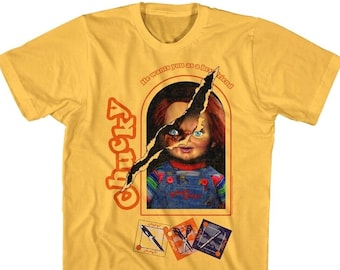 May include: Yellow t-shirt with a graphic of the character Chucky from the Child's Play movie series. The graphic shows Chucky's face peeking out of a ripped box with the text "He wants you as a best friend".