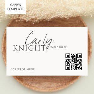 Könnte beinhalten: Weiße Tischkarte mit schwarzem Text, der "Carly Knight Table Three" lautet, und einem schwarz-weißen QR-Code. Der Text "Scan for Menu" befindet sich unter dem QR-Code.