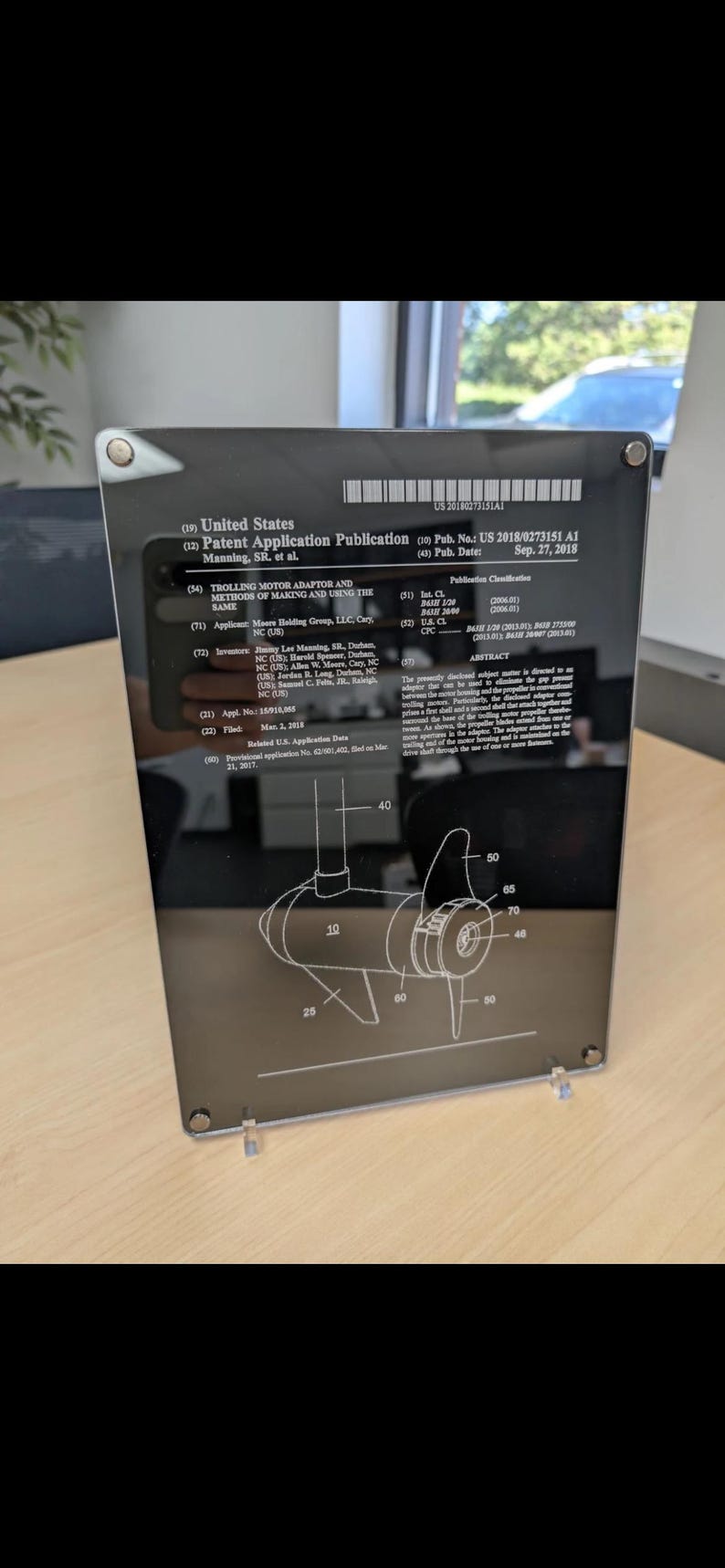 May include: A rectangular black plaque featuring a white United States Patent Application Publication for a trolling motor adaptor. The document includes technical text, a patent number, and a detailed line drawing of a motor component with labels.