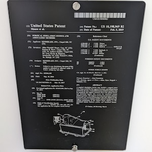 May include: A black rectangular plaque displaying the United States Patent US 10,198,969 B2 for a surgical simulation system and associated methods. The document includes technical text, patent details, and a line drawing of a simulation device.