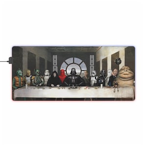 Könnte beinhalten: Eine Star Wars-Parodie von Leonardo da Vincis Das letzte Abendmahl. Die Charaktere aus dem Star Wars-Universum sind als die Jünger Jesu dargestellt, mit Darth Vader als Jesus. Zu den Charakteren gehören Yoda, Boba Fett, Chewbacca, Darth Vader, ein Stormtrooper, Jabba der Hutten und andere.