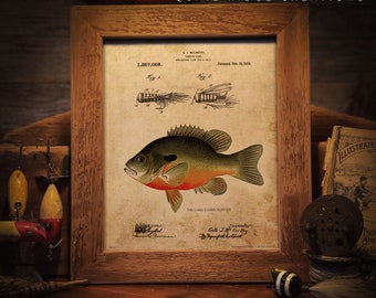 Pode incluir: Uma ilustração vintage de um peixe-sol de orelhas compridas, um tipo de peixe de água doce, com um desenho de patente de um isco de pesca. A ilustração é emoldurada em uma moldura de madeira com um passe-partout branco. O texto no desenho da patente diz "1,867,008. G.J. McCarthy, Fishing Lure.  Application filed July 18, 1929.  Patented Feb. 18, 1932."