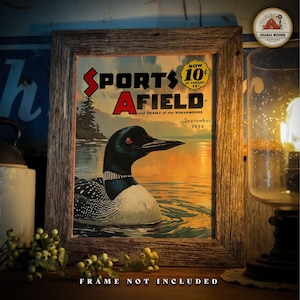 May include: A vintage framed magazine cover featuring a colorful illustration of a loon swimming in a lake at sunset. The magazine is titled "Sports Afield" and the cover date is September 1934.