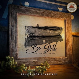 May include: A rustic wooden framed print with a vintage-style image of a small wooden boat on the water. The print has the text "Be Still and Know That I Am God" in black cursive lettering.