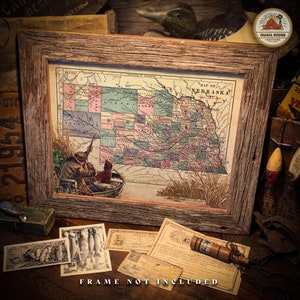 May include: A vintage map of Nebraska with a colorful county-by-county breakdown. The map is framed in a rustic wooden frame. The map is accompanied by a hunting scene of a man in a boat with a dog.