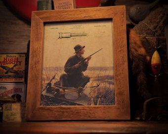 May include: A vintage-style print of a hunter in a boat with ducks, with a patent drawing of a bullet above. The print is framed in a rustic wooden frame. The text "QUAIL RIDGE CREATIONS" is at the top of the print. The text "FRAME NOT INCLUDED" is at the bottom of the print.
