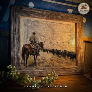 May include: A vintage-style print of a cowboy riding a horse through a field of cattle. The print features a map of Minnesota in the background. The print is framed in a rustic wooden frame.